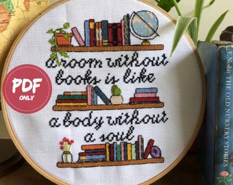 May include: A white embroidery hoop with a quote about books: "A room without books is like a body without a soul". The quote is surrounded by illustrations of bookshelves with books and plants.