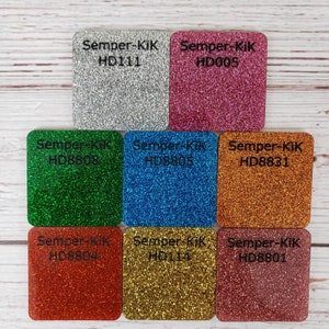 May include: Nine different colors of glitter paper, each with the text "Semper-KiK" and a product code. The colors are silver, pink, green, blue, orange, red, gold, and two shades of pink.