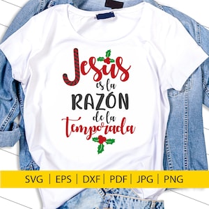 May include: White t-shirt with a red and black candy cane and green holly design. The text "Jesús es la RAZÓN de la Temporada" is written in black and red.