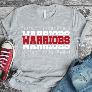 May include: Grey t-shirt with the word "WARRIORS" printed in red letters with white outlines. The word is repeated four times, with each repetition getting smaller.