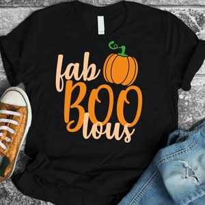 Puede incluir: Camiseta negra con el texto "fab BOO lous" en naranja y melocotón, y un pequeño gráfico de calabaza naranja.