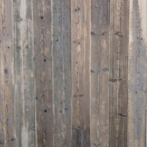 May include: A close-up of a wooden wall with vertical planks. The wood is a light brown colour with some darker brown streaks. The planks are arranged in a random pattern.