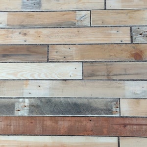 May include: A close-up of a wall made of reclaimed wood planks. The planks are arranged in a horizontal pattern and are of varying widths and colours, including light brown, dark brown, and grey. The wood has a rustic and weathered appearance.