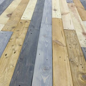 K&ouml;nnte beinhalten: Nahaufnahme eines Holzbodens aus wiederverwendeten Holzdielen in verschiedenen Graut&ouml;nen, Braun- und Beiget&ouml;nen.