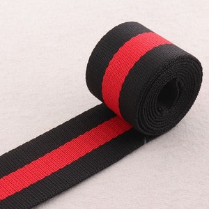 May include: Black and red striped webbing, a type of fabric tape used for straps and other applications.