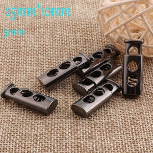 May include: Six black metal toggle clasps with a spring mechanism. Each clasp measures 25mm x 10mm x 5mm.