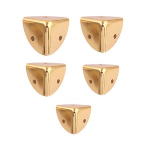 May include: Set of five gold corner protectors for furniture. Each protector has two holes for attaching to furniture.