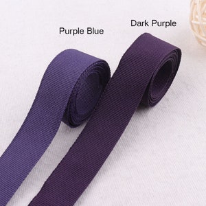 May include: Two rolls of webbing in different shades of purple. The roll on the left is labeled "Purple Blue" and the roll on the right is labeled "Dark Purple".