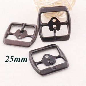 May include: Three antique bronze-coloured metal belt buckle closures, each measuring 25mm. The buckles have a rectangular shape with rounded corners and a single, centred, black metal loop.