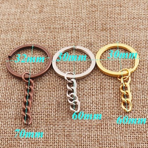 Op de afbeelding: Drie sleutelhangers met verschillende gekleurde metalen ringen en kettingen. De ringen hebben een diameter van 32 mm, 30 mm en 30 mm. De kettingen zijn 70 mm, 60 mm en 60 mm lang.