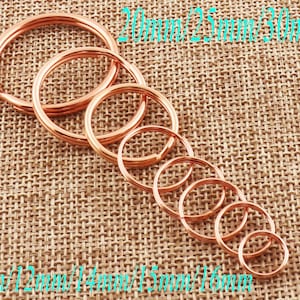 Puede incluir: Un juego de diez llaveros de metal de color dorado en varios tamaños, que van desde 10 mm hasta 30 mm de diámetro. Los llaveros están ordenados por tamaño, con el llavero más pequeño a la izquierda y el más grande a la derecha.