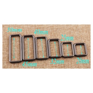 Puede incluir: Un juego de seis anillos en D de metal negro de diferentes tamaños, que van desde 20 mm hasta 50 mm. Los anillos están dispuestos en orden de tamaño, con el anillo más grande a la izquierda y el más pequeño a la derecha.