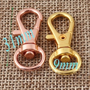 May include: Two metal keychains, one gold and one rose gold. The gold keychain has a 9mm ring and the rose gold keychain has a 31mm ring.