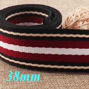 May include: Black, white and red striped webbing with gold trim. The webbing is 38mm wide.