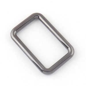 May include: A black metal D-ring with a rectangular shape.