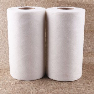 May include: Two white rolls of non-woven fabric, likely for cleaning or crafting purposes.