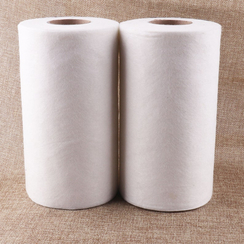 May include: Two white rolls of non-woven fabric, likely for cleaning or crafting purposes.