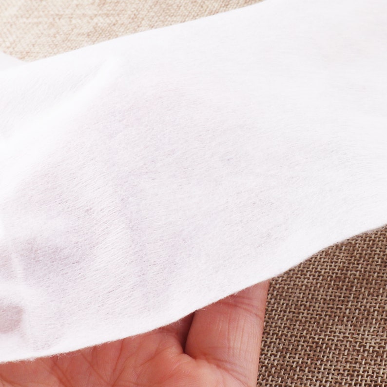 May include: A close-up of a white, soft, and textured fabric. The fabric is smooth and appears to be made of a delicate material.