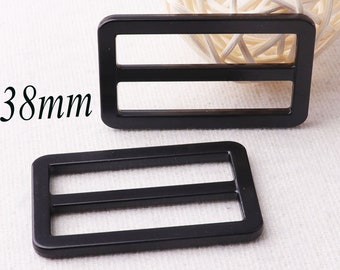 May include: Two black metal slider buckles, each with two horizontal slots. The buckles are 38mm in size.