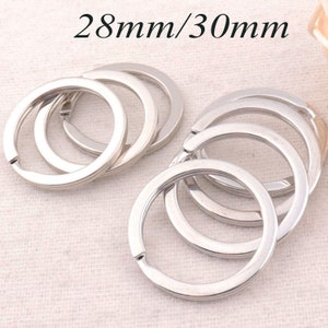 May include: A set of six silver key rings, each measuring 28mm/30mm in diameter. The rings are stacked on top of each other, showing the different sizes.