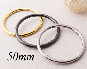 May include: Three metal rings in gold, black, and silver, each measuring 50mm in diameter.