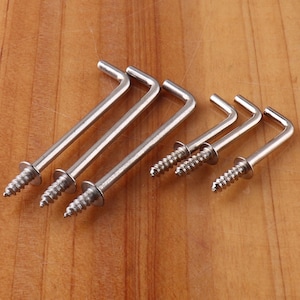 May include: Six silver metal hooks with screw threads. The hooks are L-shaped and have a rounded end.