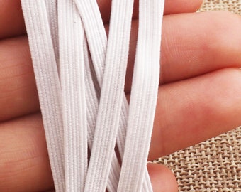 May include: White elastic cord, also known as elastic band, in a bundle of multiple strands. The elastic cord is commonly used for sewing, crafts, and DIY projects.