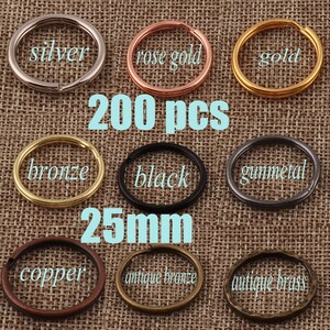 Pode incluir: Uma coleção de 200 argolas de chaveiro de metal em vários acabamentos: prata, ouro rosa, ouro, bronze, preto, metal de canhão, cobre, bronze antigo e latão antigo. Cada argola tem 25 mm de diâmetro.