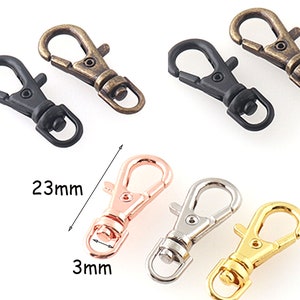 Puede incluir: Surtido de seis llaveros de metal en diferentes colores, incluyendo negro, plateado, dorado y oro rosa. Cada llavero mide 23 mm de largo y 3 mm de ancho. Los llaveros están hechos de metal duradero y cuentan con un cierre de resorte.