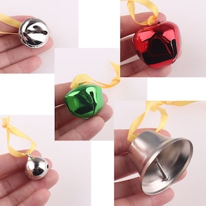 Puede incluir: Surtido de cascabeles con lazos amarillos. Los cascabeles son plateados, verdes y rojos.