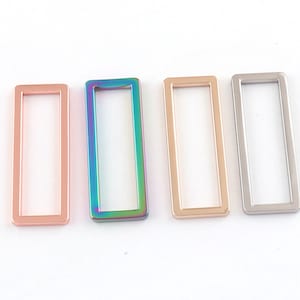 May include: Four metal rectangular jump rings in different finishes: rose gold, iridescent, gold, and silver.