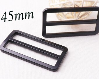 May include: Two black plastic slider buckles, each with two parallel slots. The buckles are 45 mm in size.