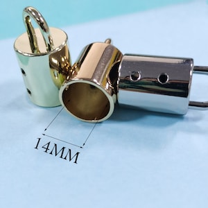 Puede incluir: Tres tapones metálicos para una correa de bolso. Dos son dorados y uno es plateado. Los tapones dorados tienen un bucle en la parte superior. El tapón plateado tiene un gancho en la parte superior. Los tapones tienen un diámetro de 14 mm.