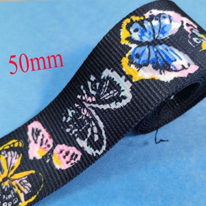 May include: Black webbing with a colorful butterfly print. The webbing is 50mm wide.