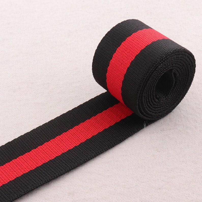May include: Black and red striped webbing, a type of fabric tape used for straps and other applications.