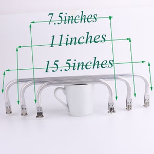 May include: Five silver-colored metal handbag handles with a hook design. The handles are 15.5 inches long, 1 inch wide, and 7.5 inches tall.