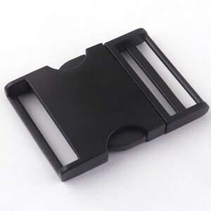 May include: Black plastic side release buckle. The buckle is designed to be used with webbing or straps.