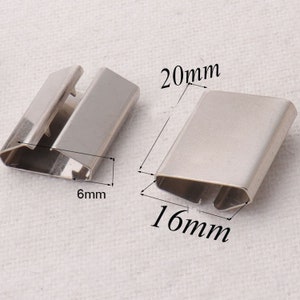May include: Two silver metal banding straps for securing packages. The larger strap measures 20 mm by 16 mm, and the smaller strap measures 6 mm wide.