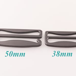 K&ouml;nnte beinhalten: Zwei schwarze Metall-BH-Gurtversteller, einer mit einer L&auml;nge von 50 mm und der andere mit 38 mm.