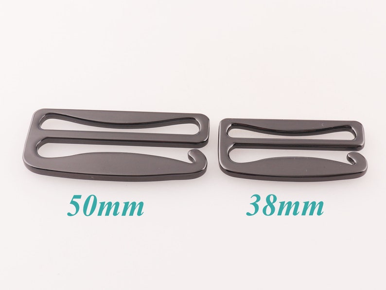 K&ouml;nnte beinhalten: Zwei schwarze Metall-BH-Gurtversteller, einer mit einer L&auml;nge von 50 mm und der andere mit 38 mm.