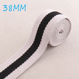 Puede incluir: Cinta de algodón blanca con una raya negra, de 38 mm de ancho.