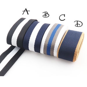 Könnte beinhalten: Vier Rollen gestreiftes Gurtband in Schwarz-Weiß, Marineblau-Weiß, Grau-Blau und Marineblau-Braun. Die Rollen sind mit A, B, C und D gekennzeichnet.