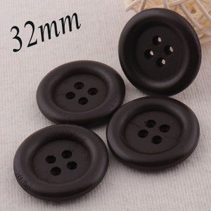 Puede incluir: Cuatro botones de madera marrón con cuatro agujeros cada uno. Los botones tienen un diámetro de 32 mm.