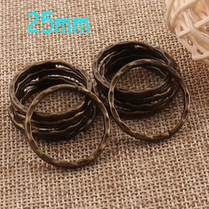 May include: A close-up of 25mm antique brass jump rings. The rings are stacked and have a hammered texture.