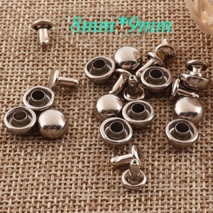 Op de afbeelding: Een close-up van een stapel zilveren metalen klinknagels. De klinknagels zijn 8 mm bij 9 mm groot.