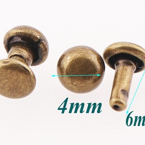 May include: Three antique gold-toned metal rivets, two with a round head and one with a flat head. The round head rivets measure 4 mm in diameter and the flat head rivet measures 6 mm in diameter.