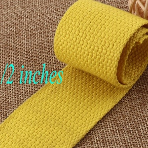 Pode incluir: Um rolo de fita de algodão amarela de 3,8 cm de largura. A fita tem uma superfície texturizada e é perfeita para projetos de artesanato.