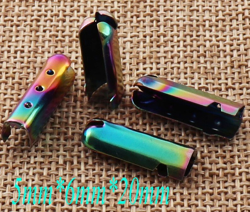 May include: Four iridescent metal cord ends. Each cord end is a rectangular shape with a curved top and a slot for cord insertion. The cord ends are approximately 0.2 inches wide, 0.24 inches high, and 0.8 inches long.