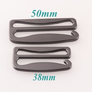 K&ouml;nnte beinhalten: Zwei schwarze Metall-BH-Verl&auml;ngerungen, eine mit einer L&auml;nge von 50 mm und die andere mit 38 mm.