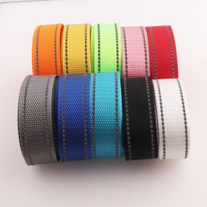 Peut inclure: Assortiment de dix sangles réfléchissantes en sangle de 2,5 cm de large dans différentes couleurs, notamment gris, bleu, turquoise, noir, blanc, rouge, rose, vert, jaune et orange. Chaque sangle est dotée d'une bande réfléchissante argentée qui court le long du centre.